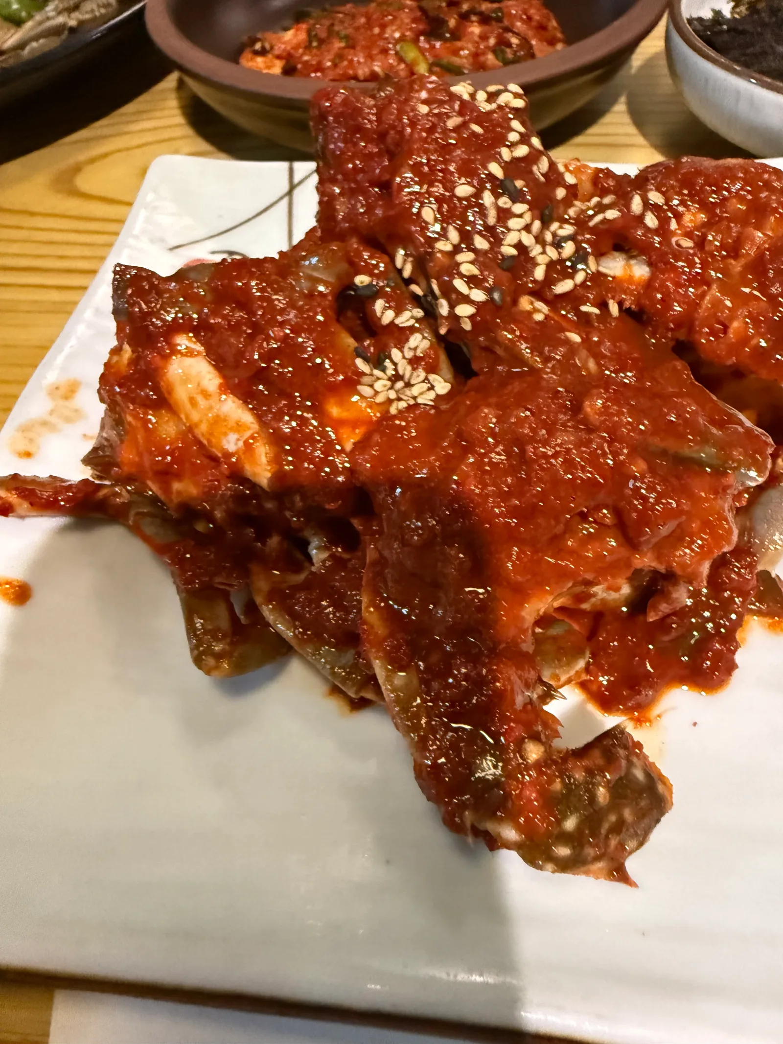 흰 사각 접시에 담긴 양념게장, 참깨가 뿌려져 있다