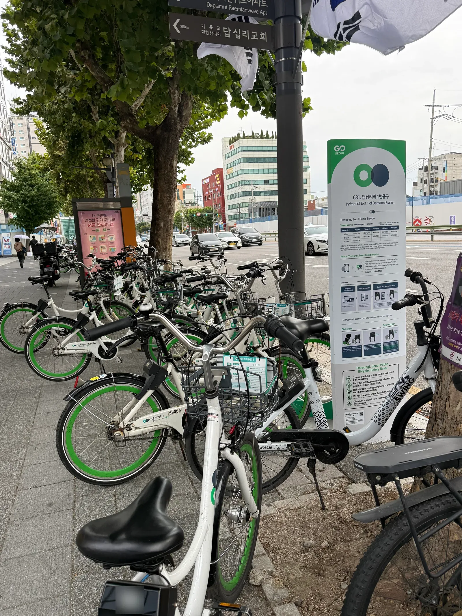 A row of Ttareungyi bikes on the pavement beside a rental-station sign reading 631. In front of Exit 1 of Dapsimni Station